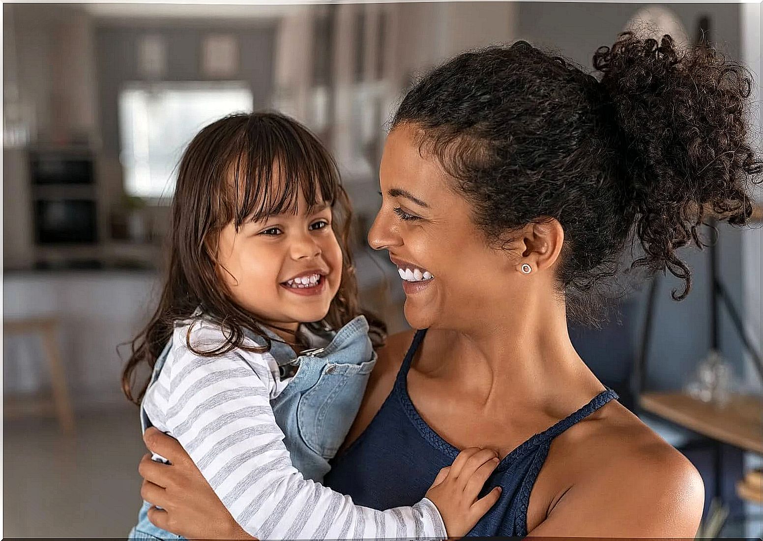 Mother hugging her daughter and saying phrases to express love.