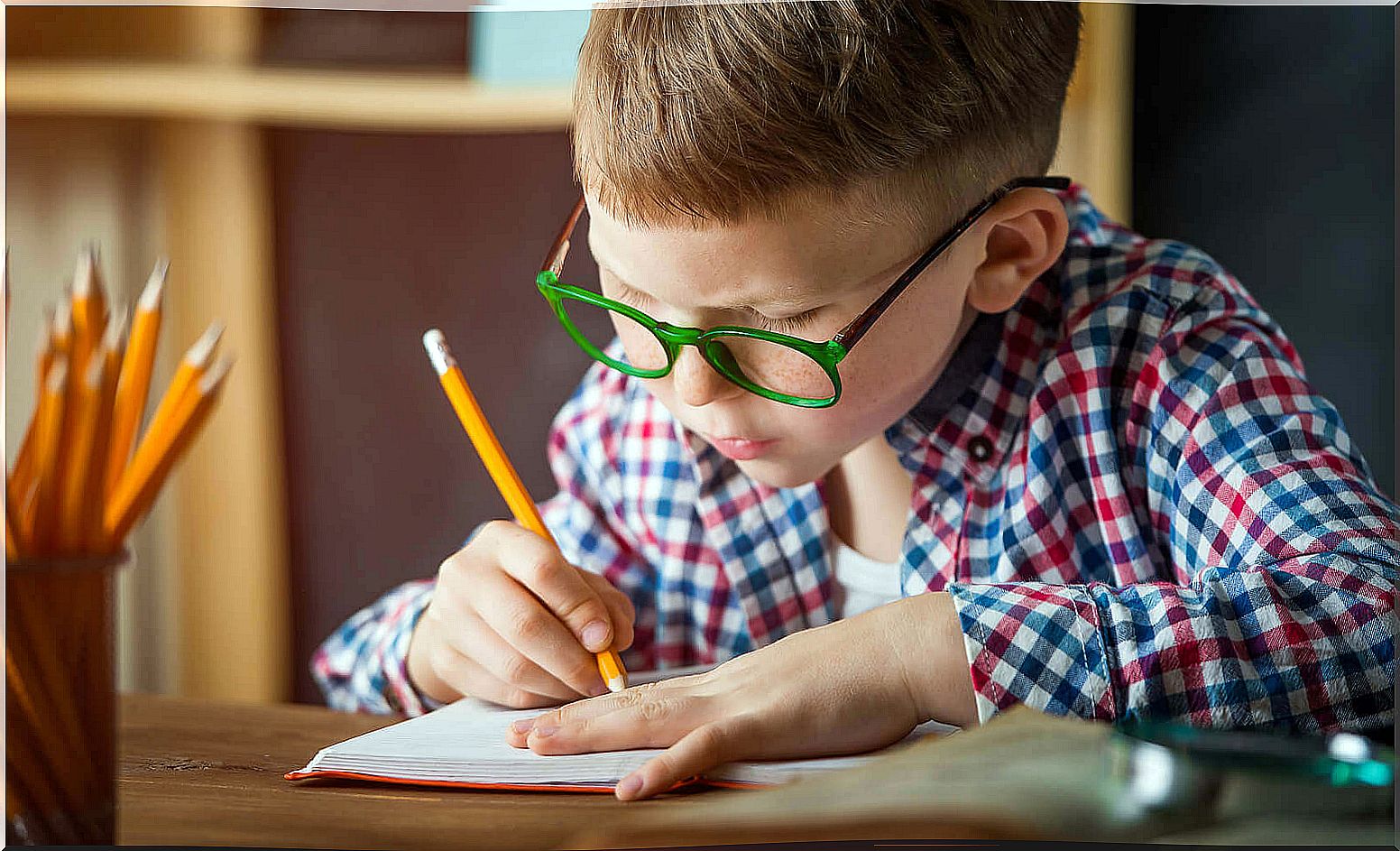 Boy learning to write by hand.