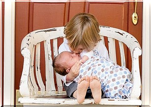 boy with younger brother on his lap kissing him