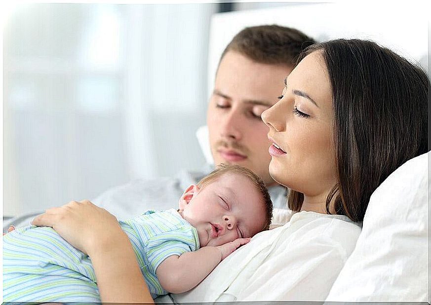 parents sleeping with baby in arms