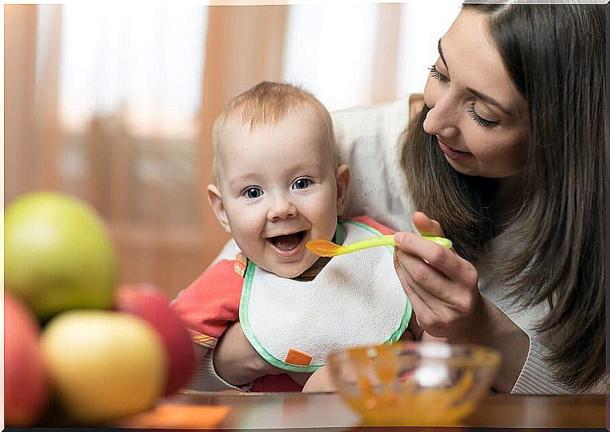 mother giving baby food 