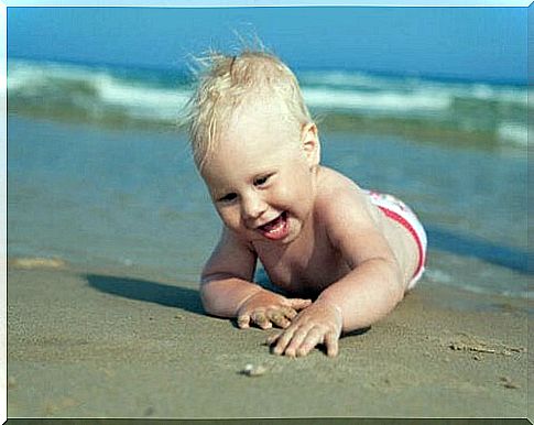 baby crawling on the beach sand